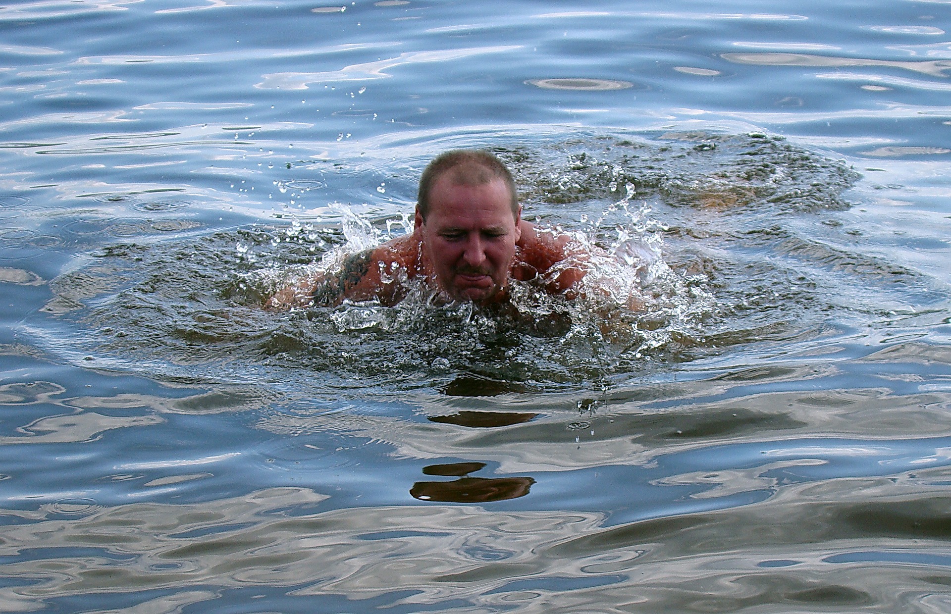 Мужчина купается в море